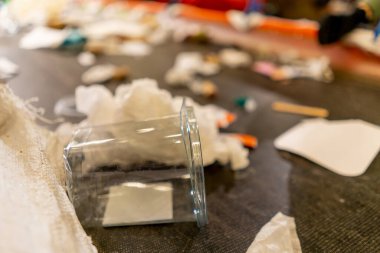 Bir atık geri dönüşüm tesisinde atık sıralama hattında bulunan plastik şişe ve poşetlerin yakın çekim görüntüleri.