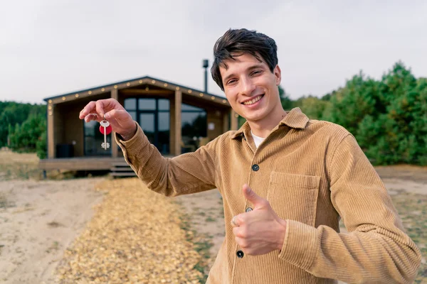 Guy Holds Bunch Keys His New House Background Wooden Cabin — Stock Photo, Image