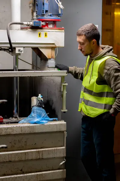Ein Mitarbeiter Einer Recyclinganlage Uniform Füllt Müllsäcke Eine Spezielle Pressmaschine — Stockfoto