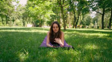 Eğitimden önce ya da sonra parkta yürüyüş yaparken elinde akıllı telefonu tutan aktif, güzel bir Yogi kadını.