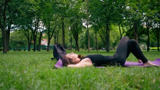 Aktiv Vacker Yogi Kvinna Vilar Stadsparken Efter Träning Liggande Träningsmatta — Stockvideo