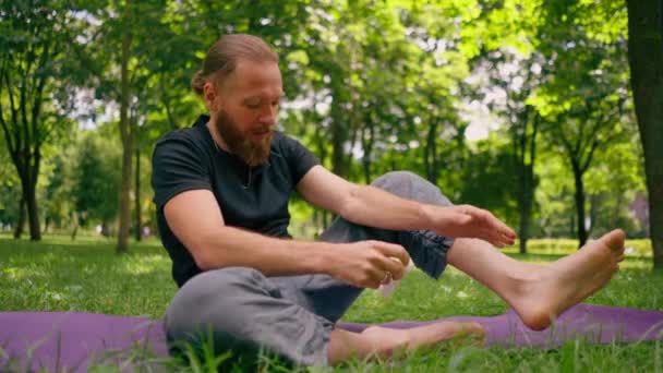 Portret Knappe Bebaarde Man Mediteren Het Park Zitten Lotuspositie Beoefenen — Stockvideo