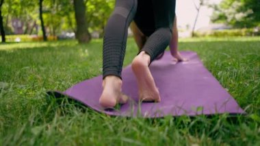 Yakın plan atletik sıska, ayakları yoga meditasyonu için mindere basan bir kadının ayakları şişmiş.