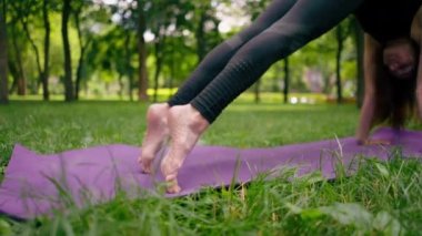 Yakın plan atletik sıska, ayakları yoga meditasyonu için mindere basan bir kadının ayakları şişmiş.