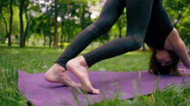Yakın plan atletik sıska, ayakları yoga meditasyonu için mindere basan bir kadının ayakları şişmiş.