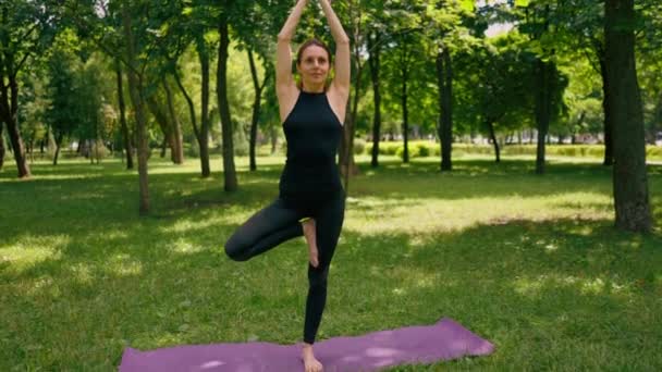 Erfaren Kvinnlig Instruktör Mediterar Parken Utövar Yoga Sträcker Sig Ett — Stockvideo