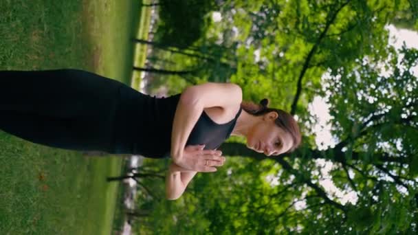 一位经验丰富的女教师在公园里冥想时练习瑜伽 练习伸展和锻炼不同的肌肉群 — 图库视频影像