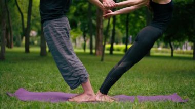 aşık çiftler ya da yoga hocası ve kadın şehir parkında egzersiz yapıyorlar.