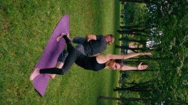 aşık bir çift ya da yoga eğitmeni ve kadın şehir parkında egzersiz yapıyorlar. Asana ruhani uygulaması sağlıklı vücut kasları.