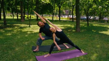 aşık çiftler ya da yoga hocası ve kadın şehir parkında egzersiz yapıyorlar.