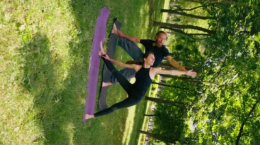aşık bir çift ya da yoga eğitmeni ve kadın şehir parkında egzersiz yapıyorlar. Asana ruhani uygulaması sağlıklı vücut kasları.