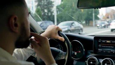 Şehrin içinde lüks bir arabanın içinde direksiyonun başında bir erkek sürücünün saatiyle el ele tutuşun.