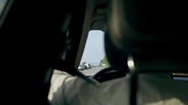 Sürücü aynasındaki arka koltuktan lüks bir araba manzaralı siyah deri iç mekan.