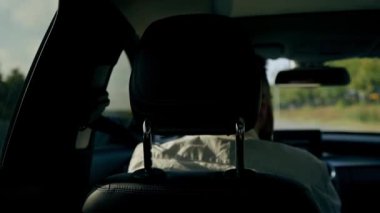 Sürücü aynasındaki arka koltuktan lüks bir araba manzaralı siyah deri iç mekan.