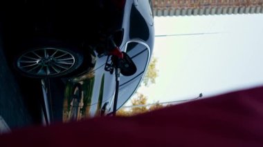 Yakından çekilen dikey video benzinli bir arabaya yakıt ikmali konsepti benzin pompası enjektörüyle benzin ikmali.