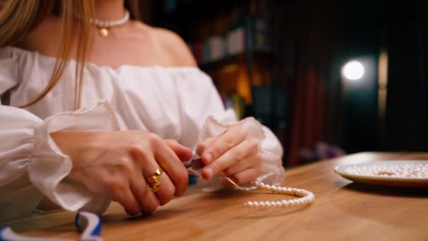 小女孩的特写用手做珠宝用她自己的手剪断剩余的金属丝做项链用钳子手工制作 — 图库视频影像