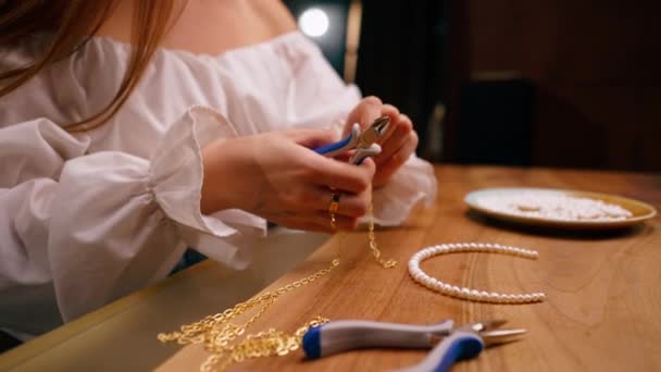 小女孩的特写用手做珠宝用她自己的手剪断剩余的金属丝做项链用钳子手工制作 — 图库视频影像