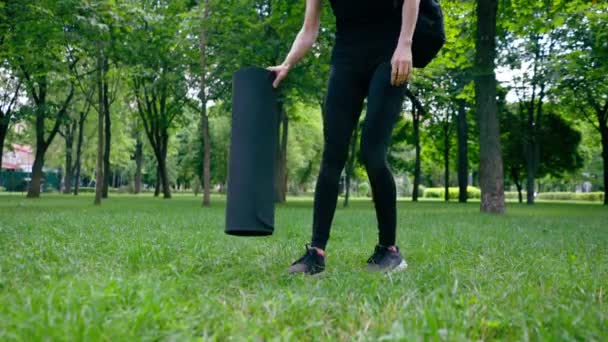 在训练前或训练后 在公园里散步时 积极的 漂亮的瑜伽女子会拿着健身垫站着 — 图库视频影像