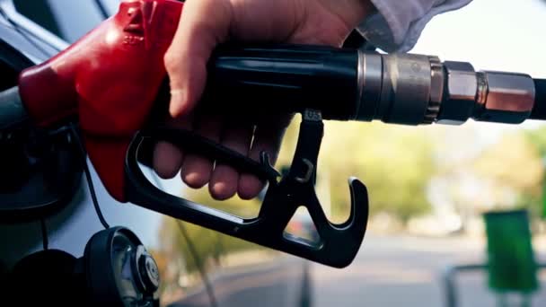 ガソリンスタンド車の給油車のためのクローズアップハンド保持ガソリンノズル 燃料補給ガソリン燃料の旅行輸送と休暇 — ストック動画