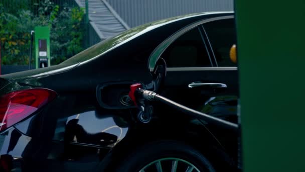 クローズアップ 燃料ポンプのノズルが付いているガソリンスタンドの燃料ディスペンサーで車に給油するという概念 — ストック動画