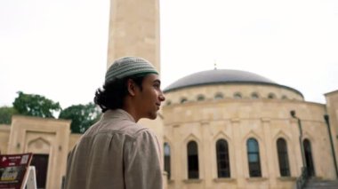 Genç bir Arap 'ın, bir caminin iç avlusuna terasta İslami süslemelerle girerken çekilmiş bir fotoğrafı.