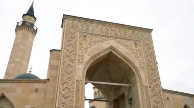 Mavi gökyüzüne karşı İslami süslemelerle çevrili bir Müslüman camisine güzel bir giriş.
