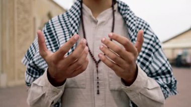 Dönüşüm ve Allah 'a ibadet sırasında tespih tutan Müslüman bir adamın elleri.