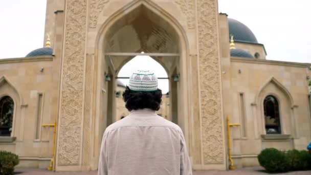 イスラム教の装飾を持つテラスにモスクの中庭に入る若いアラブ人の背中のショット — ストック動画