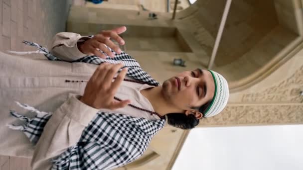 一名身穿民族服装 脖子上挂着念珠的阿拉伯男子在清真寺院子里祈祷的特写 — 图库视频影像