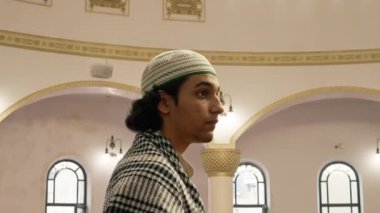Cami salonunun ortasında büyük pencereli ve avizesi parlayan bir Müslüman başını kaldırıyor.