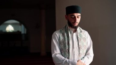 Müslüman bir adamın portresi Ramazan 'da diz çöküp camideki manevi refah ve destek için şükrediyor.