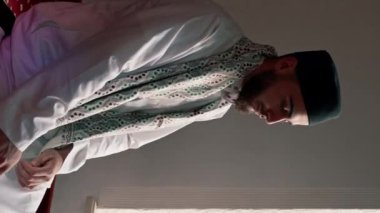 Müslüman bir adamın portresi Ramazan 'da diz çöküp camideki manevi refah ve destek için şükrediyor.