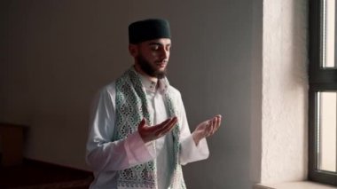 Müslüman bir adamın Ramazan 'da bir İslam tapınağında diz çöküp namaz kıldığı yakın çekim.