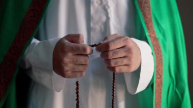 Dönüşüm ve Allah 'a ibadet sırasında tespih tutan Müslüman bir adamın elleri.