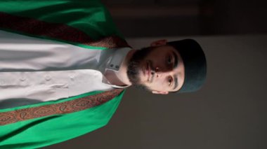 Müslüman bir adamın portresi Ramazan 'da diz çöküp camideki manevi refah ve destek için şükrediyor.