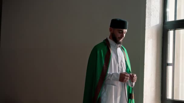 在斋月 一名阿拉伯牧师穿着民族服装站在清真寺里 古兰经 的帮助下向真主祈祷 — 图库视频影像
