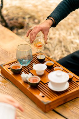 Bir çay seremonisi için kaynamış suyla ahşap bir masada özel bir seramik kase ve kase sergilenir.