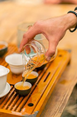 Geleneksel çay seremonisi sırasında seramik kaselere konan mayalanmış doğal Çin çayının yakın plan çekimi.