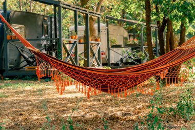 Kamp alanlarındaki ağaçlara bağlı bir hamak. Dinlenme ve gezginlerin dinlenmesi için motorlu evler.