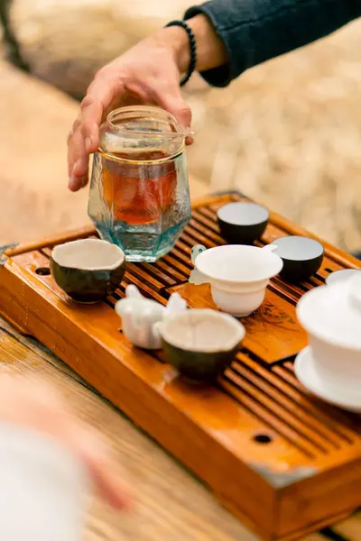 在一个木制桌子上陈列着一套特殊的陶瓷碗和碗 上面放着用于茶道的开水 — 图库照片