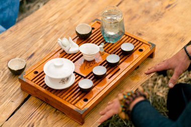 Bir çay seremonisi için kaynamış suyla ahşap bir masada özel bir seramik kase ve kase sergilenir.