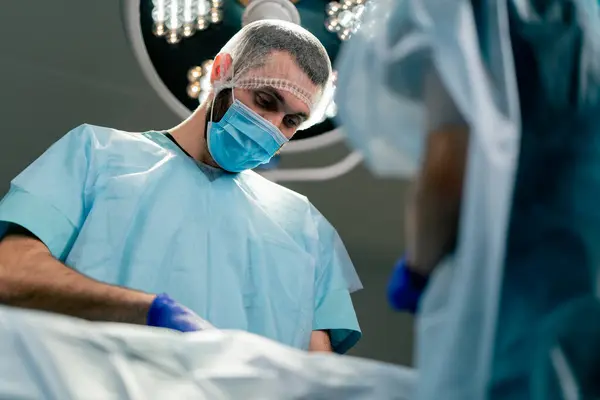 Médicos Cirurgiões Concentrados Uniformes Protetores Máscaras Médicas Realizam Uma Operação — Fotografia de Stock