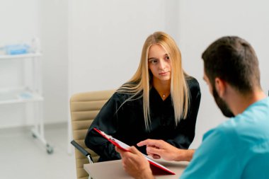Tıp merkezindeki bir doktor kıza testlerini gösterir ve ilave bir tedavi önerir.