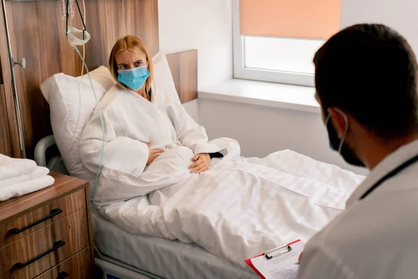 Girl Hospital Room Medical Mask Holds Her Stomach Her Hand — Stock Photo, Image