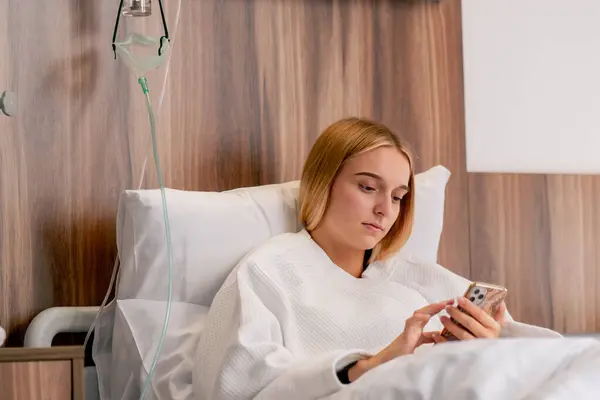 Sad Girl Bathrobe Lies Hospital Room Sadly Looks Her Phone — Stock Photo, Image