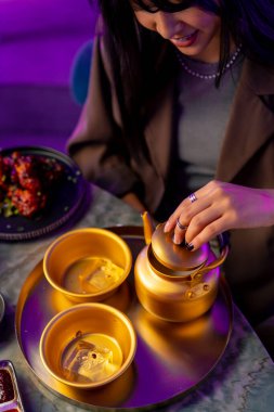 Lokantada geleneksel Kore meşrubatlı buzlu çay fincanı ve altın çaydanlık servis ediliyor.