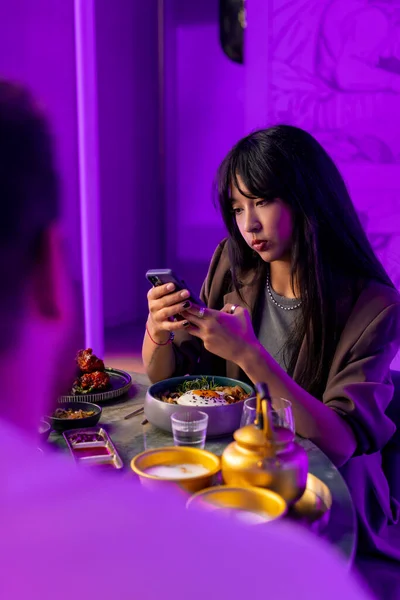 Genç Bir Kız Akıllı Telefonuyla Kore Restoranındaki Bir Çaydanlıkta Içki — Stok fotoğraf
