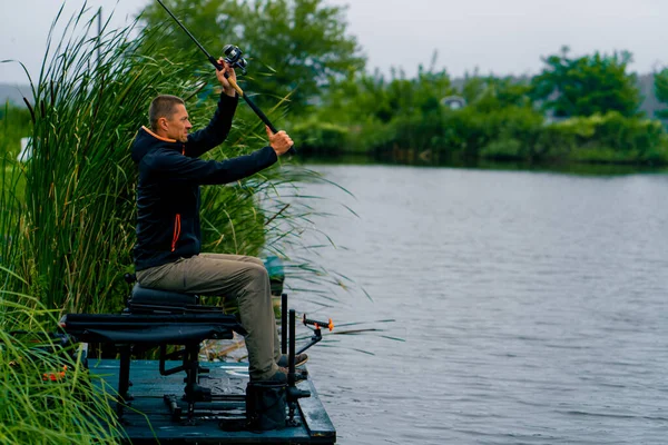 Fischer Wirft Eine Angelrute Oder Spinnrute Ins Wasser Während Ufer — Stockfoto