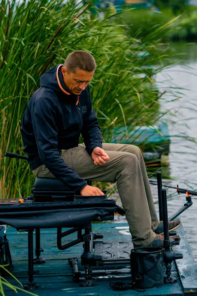 Balıkçı Elinde Olta Olta Profesyonel Aletlerle Nehir Kıyısında Oturup Balık — Stok fotoğraf