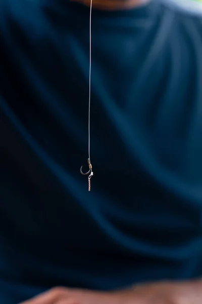 釣り糸を持っている男性のクローズアップまたはフリースタイル釣りのためのフィーダーホックで飛ぶ — ストック写真